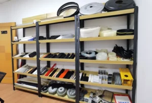 Samples of custom extruded plastic profiles, tubes, rods and gaskets organized on display shelves