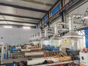 Wide view of multiple extrusion lines with overhead exhaust hoods and control panels