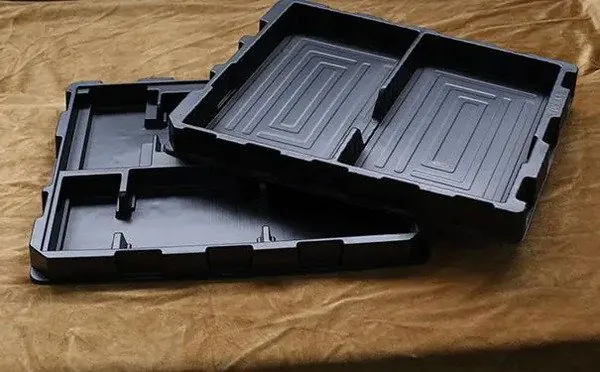 Two nested black thermoformed trays